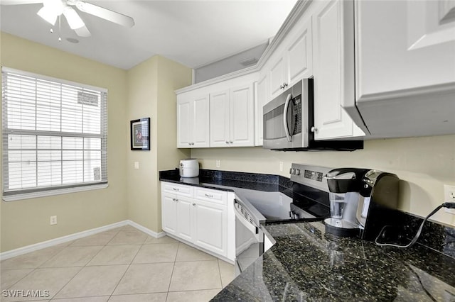 kitchen featuring a ceiling fan, light tile patterned floors, baseboards, appliances with stainless steel finishes, and white cabinetry