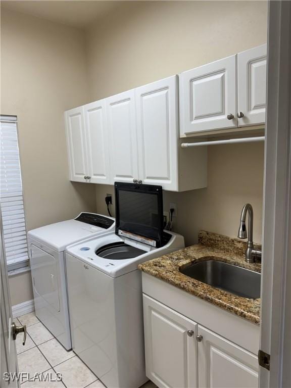 3323 SW 25th Ct, Cape Coral, FL 33914 - laundry room featuring washing machine and dryer, cabinet space, light tile patterned flooring, and a sink