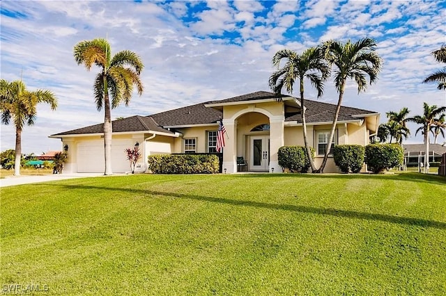 3323 SW 25th Ct, Cape Coral, FL 33914 - view of front of property with a garage, concrete driveway, a front lawn, and stucco siding