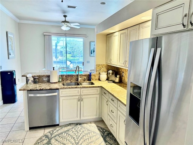 3323 SW 25th Ct, Cape Coral, FL 33914 - kitchen with stainless steel appliances, a peninsula, a sink, crown molding, and light tile patterned floors