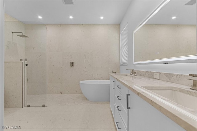 595 31st St NW, Naples, FL 34120 - bathroom with walk in shower, a freestanding tub, double vanity, and recessed lighting