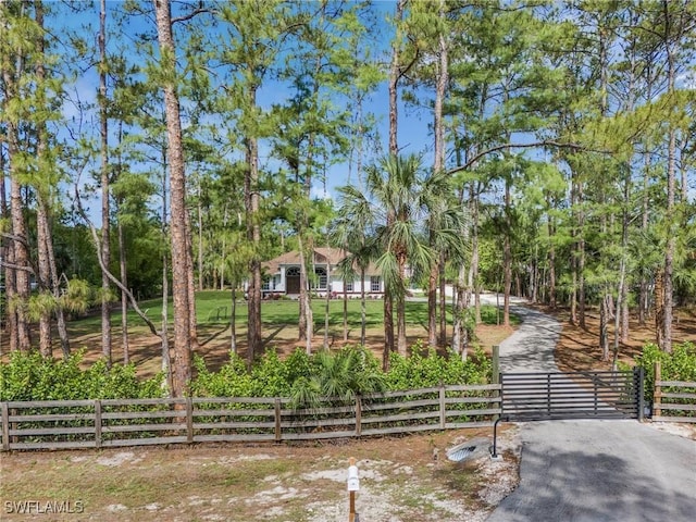 595 31st St NW, Naples, FL 34120 - view of front of home featuring view of scattered trees and a gate