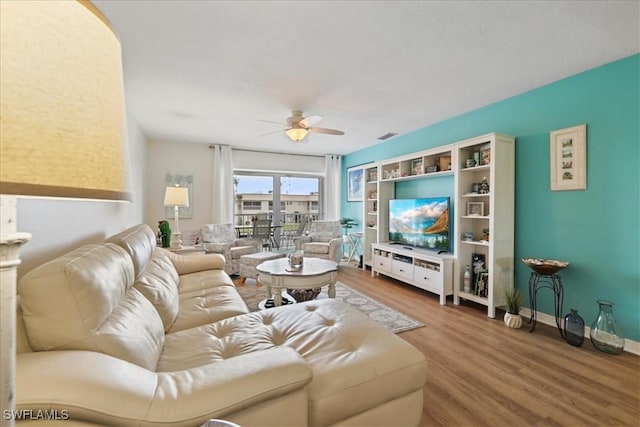 living area with ceiling fan and wood finished floors