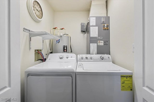 laundry area with laundry area, heating unit, washing machine and dryer, and water heater