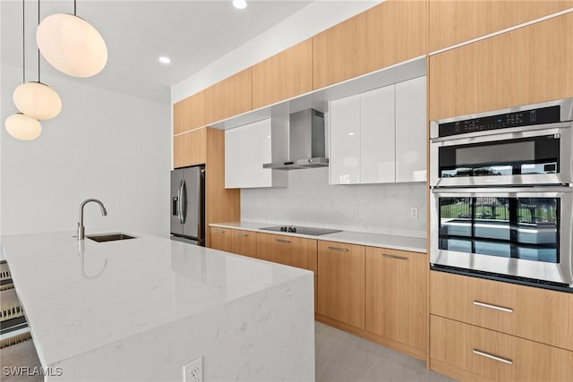 kitchen with appliances with stainless steel finishes, wall chimney range hood, a sink, modern cabinets, and recessed lighting