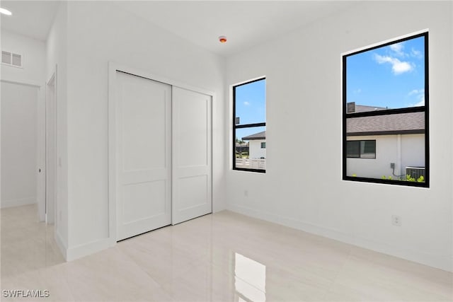 unfurnished bedroom with baseboards, a closet, and tile patterned flooring