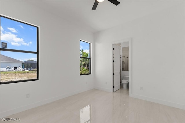 unfurnished bedroom featuring baseboards, connected bathroom, and ceiling fan