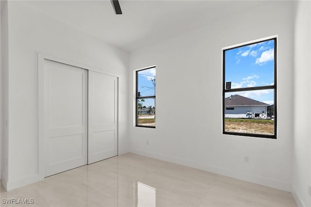 unfurnished bedroom featuring a closet, baseboards, and ceiling fan