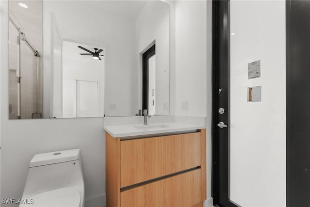 bathroom with vanity, toilet, and ceiling fan