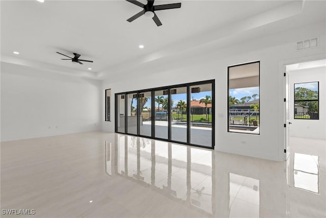unfurnished room featuring a raised ceiling, ceiling fan, and recessed lighting
