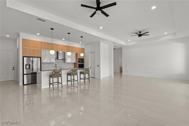 living room featuring a ceiling fan, recessed lighting, a raised ceiling, and light tile patterned floors
