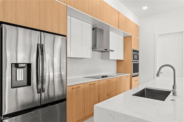 kitchen featuring stainless steel refrigerator with ice dispenser, wall chimney exhaust hood, black electric cooktop, a sink, and modern cabinets