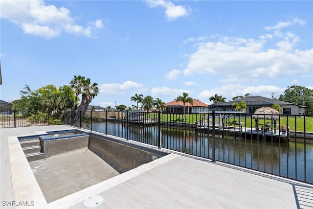 view of patio / terrace with a water view and fence