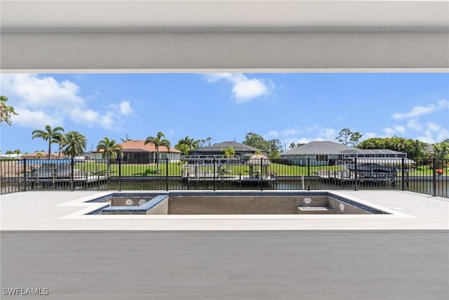 view of pool with a residential view, fence, and a water view