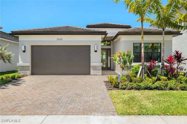 20321 Fair Oak Ln, Estero, FL 33928 - prairie-style house with an attached garage, stucco siding, stone siding, and decorative driveway
