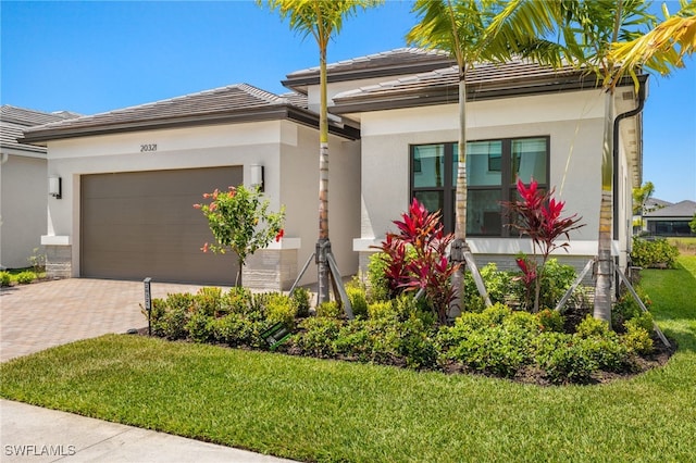 20321 Fair Oak Ln, Estero, FL 33928 - view of front of house with a tile roof, a front lawn, a garage, stucco siding, and decorative driveway