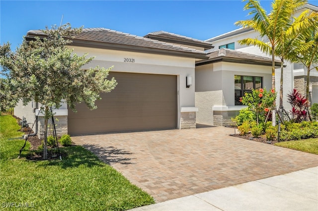20321 Fair Oak Ln, Estero, FL 33928 - prairie-style home featuring a tile roof, decorative driveway, stone siding, an attached garage, and stucco siding