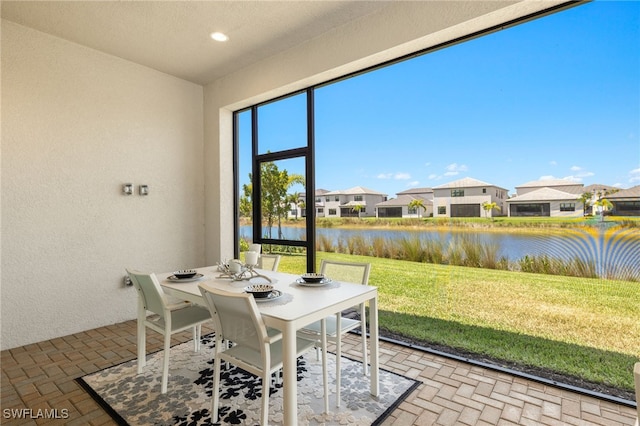 20321 Fair Oak Ln, Estero, FL 33928 - dining area with a residential view, a textured wall, a water view, recessed lighting, and brick floor