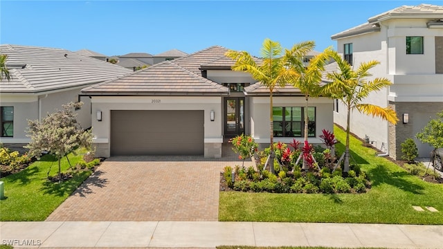 20321 Fair Oak Ln, Estero, FL 33928 - view of front of property featuring an attached garage, decorative driveway, a tiled roof, and a front lawn