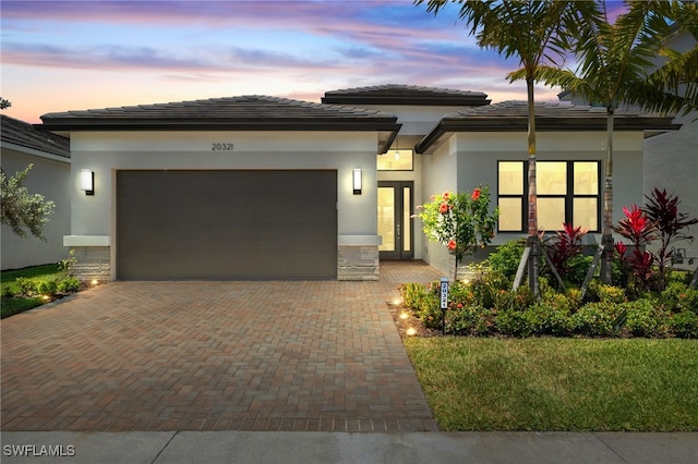 20321 Fair Oak Ln, Estero, FL 33928 - prairie-style home with stucco siding, decorative driveway, a tiled roof, and a garage