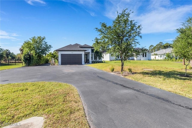 view of front of property featuring a garage, a front yard, and aphalt driveway
