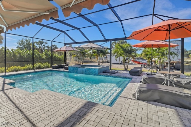 pool with a patio area, glass enclosure, and an in ground hot tub