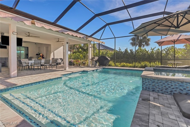 view of swimming pool featuring glass enclosure, a ceiling fan, outdoor dining area, a patio, and a pool with connected hot tub