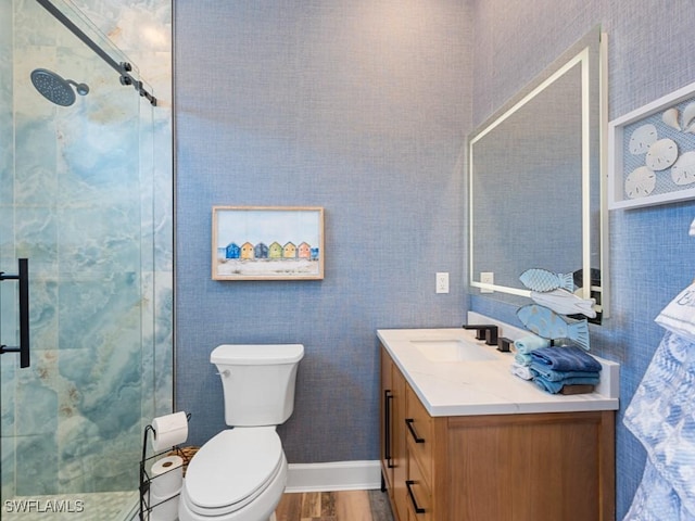 full bathroom with toilet, wood finished floors, vanity, and a stall shower