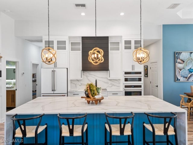 kitchen featuring a chandelier, visible vents, white cabinetry, and white appliances