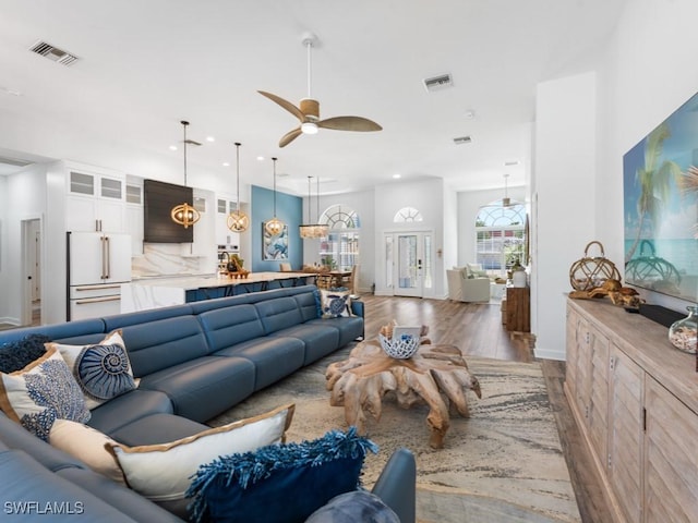 living room featuring a ceiling fan, wood finished floors, visible vents, and recessed lighting