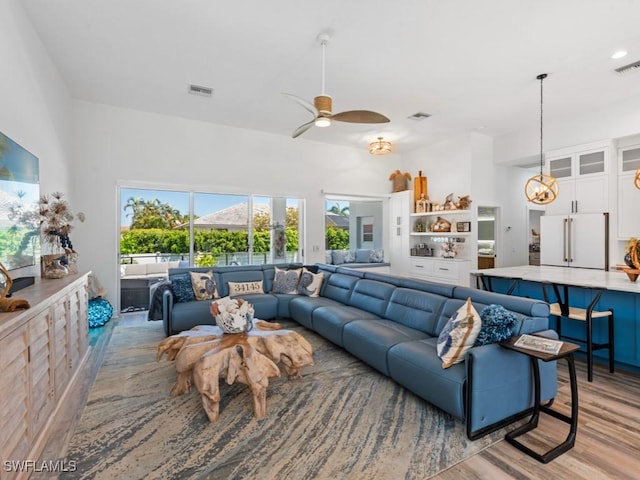 living area featuring ceiling fan, a wealth of natural light, visible vents, and light wood-type flooring