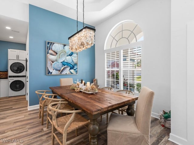 dining room with baseboards, stacked washer / dryer, wood finished floors, and recessed lighting