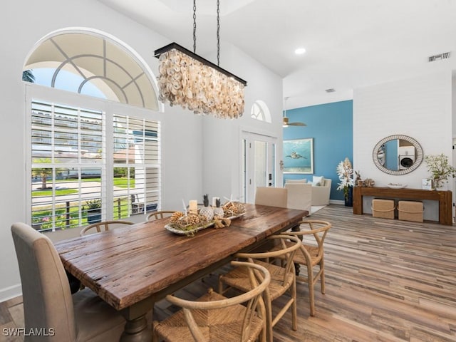 dining area featuring baseboards, wood finished floors, visible vents, and a wealth of natural light