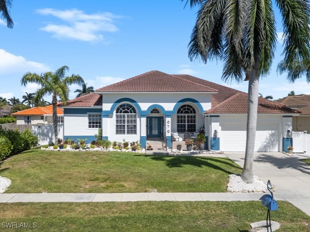 view of front of property with fence, stucco siding, an attached garage, a tile roof, and driveway