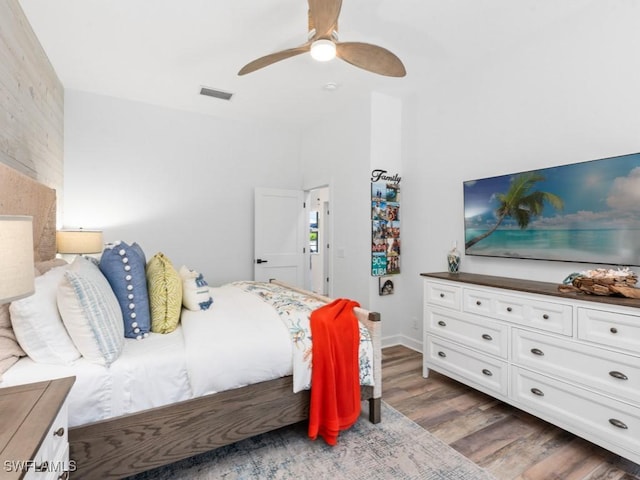 bedroom with wood finished floors, visible vents, and ceiling fan