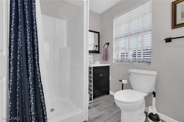 264 Mamie St, Chokoloskee, FL 34138 - full bathroom with wood finished floors, toilet, vanity, baseboards, and a stall shower