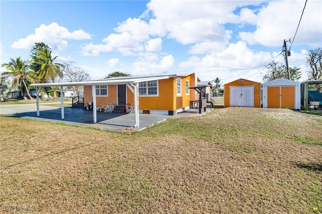 264 Mamie St, Chokoloskee, FL 34138 - rear view of property with entry steps, a yard, an outdoor structure, a patio, and a storage unit