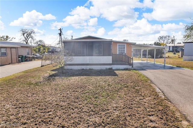 264 Mamie St, Chokoloskee, FL 34138 - view of front facade featuring a sunroom, a carport, driveway, and a front yard