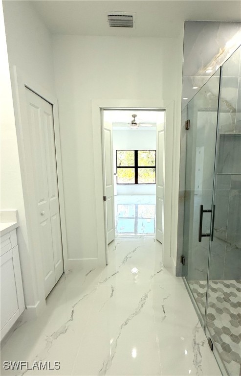full bath with visible vents, baseboards, vanity, a marble finish shower, and marble finish floor