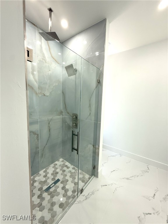 bathroom featuring recessed lighting, marble finish floor, baseboards, and a stall shower