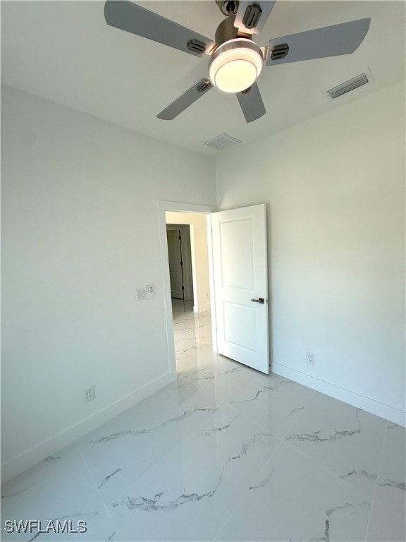 unfurnished bedroom with marble finish floor, baseboards, a ceiling fan, and visible vents