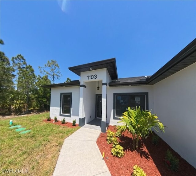 view of front of house featuring a front yard and stucco siding