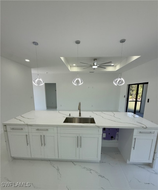 kitchen featuring a large island with sink, white cabinets, recessed lighting, a sink, and open floor plan