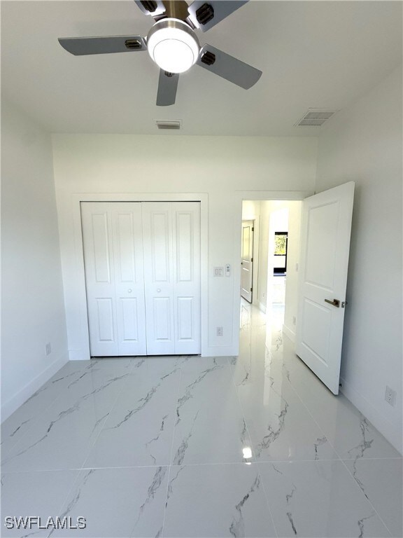 unfurnished bedroom with visible vents, baseboards, and a closet