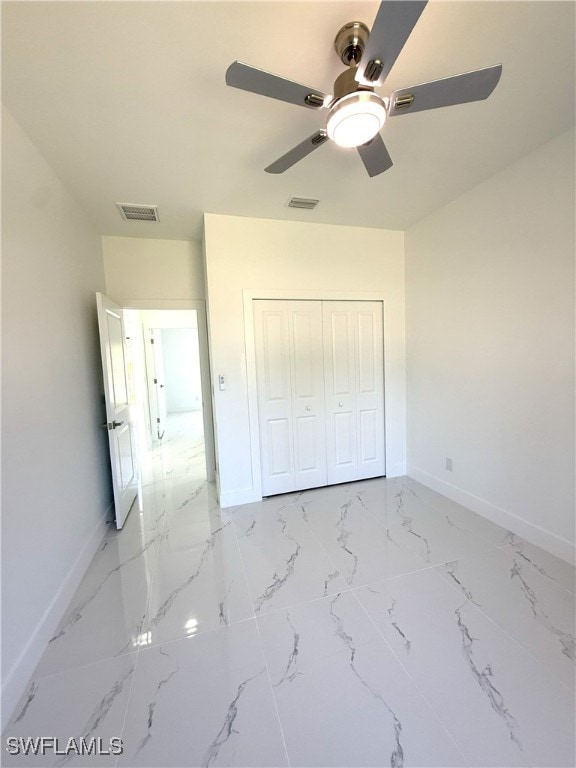 unfurnished bedroom with a closet, marble finish floor, baseboards, and visible vents