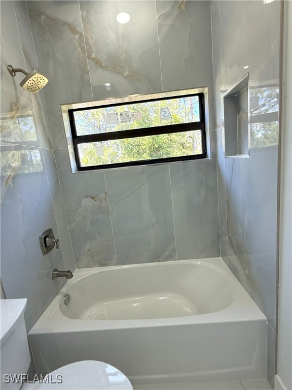 bathroom with toilet and shower / washtub combination