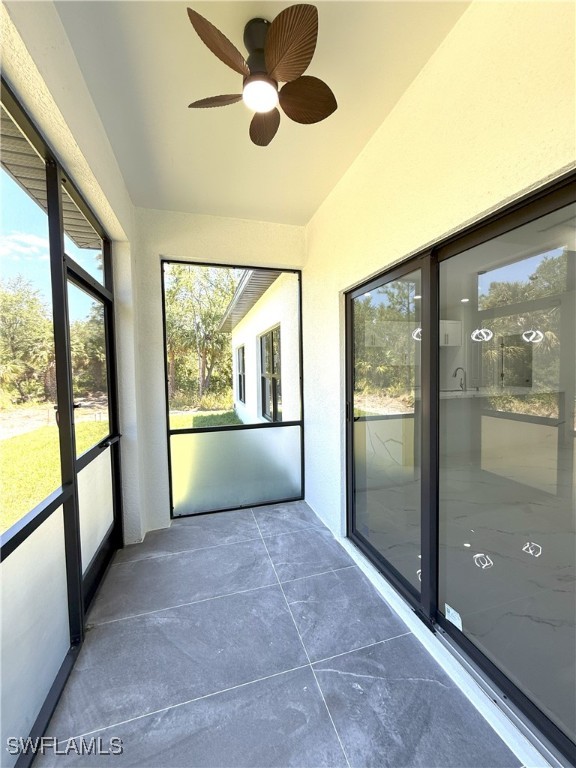 unfurnished sunroom with ceiling fan