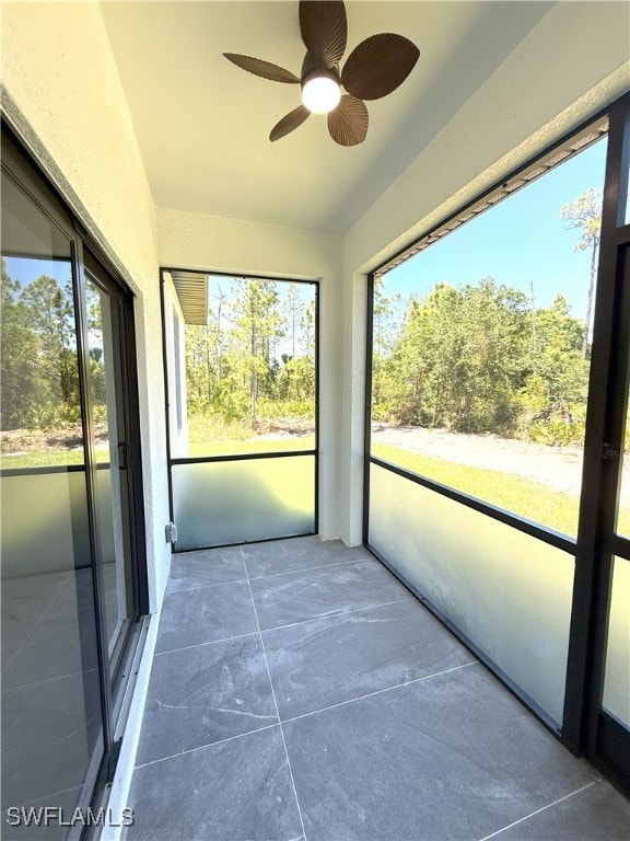 unfurnished sunroom featuring a ceiling fan