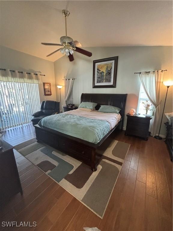 bedroom with access to exterior, hardwood / wood-style floors, a ceiling fan, and lofted ceiling