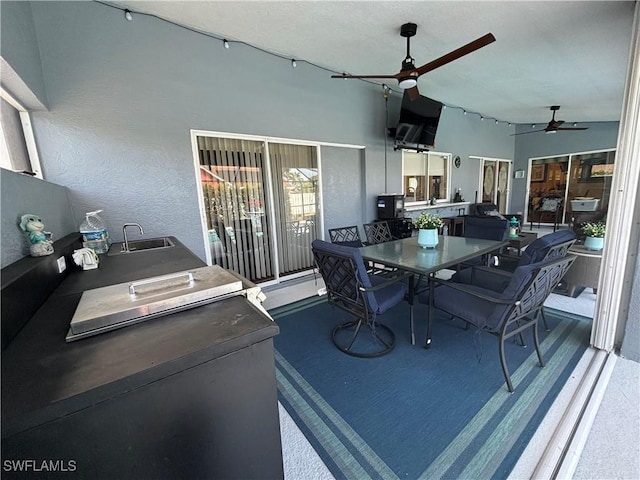 view of patio / terrace featuring outdoor dining area, a sink, and ceiling fan
